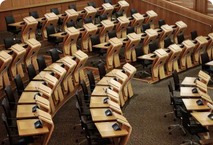 Rows of wooden seats in an empty council chamber
